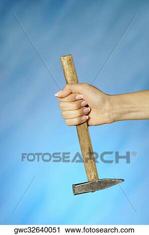 Stock Image - Close-up of a woman's hand holding a hammer. Fotosearch