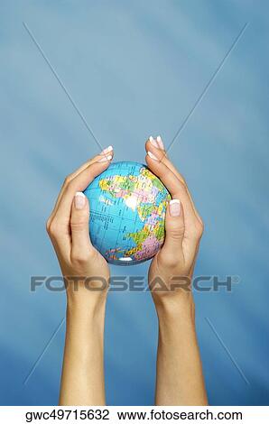 Stock Image - Close-up of a woman's hands holding a globe. Fotosearch
