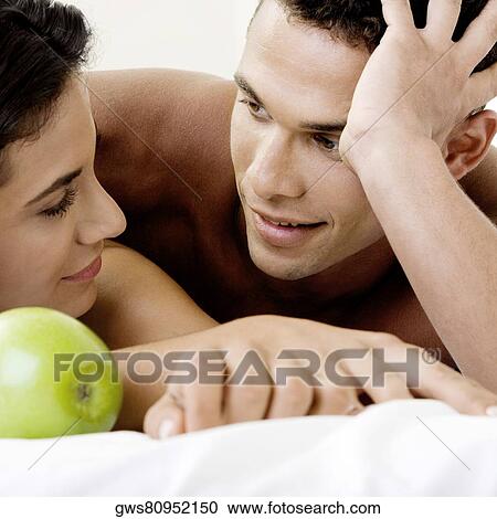 Stock Image - Close-up of a young couple smiling. Fotosearch