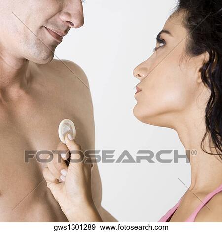 Close-up of a young man and a young woman holding a condom View Large Photo Image Stock Photo - Close-up of a young man and a young woman holding a condom. Fotosearch