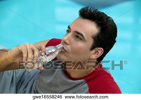 Close-up of a young man drinking water from a water bottle View Large Photo Image Stock Photograph - Close-up of a young man drinking water from a water bottle. Fotosearch