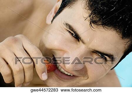 Close-up of a young man eating a strawberry View Large Photo Image Stock Image - Close-up of a young man eating a strawberry. Fotosearch