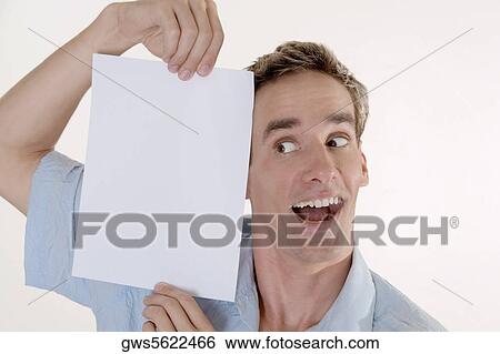 Close-up of a young man holding a sheet of blank paper View Large Photo Image Stock Photograph - Close-up of a young man holding a sheet of blank paper. Fotosearch