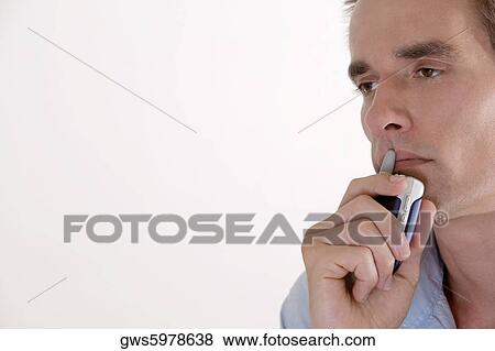 Close-up of a young man holding a mobile phone View Large Photo Image Stock Photo - Close-up of a young man holding a mobile phone. Fotosearch
