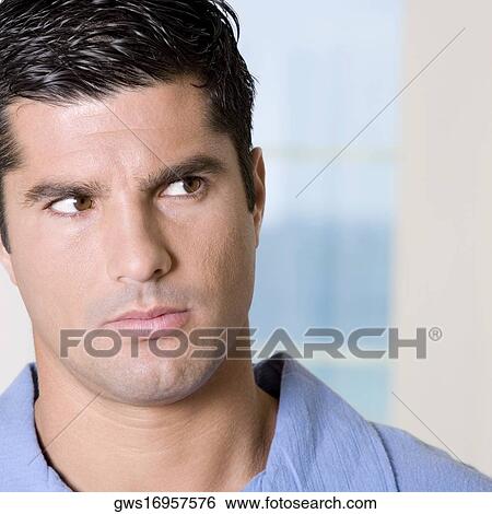 Stock Photograph - Close-up of a young man looking serious. Fotosearch