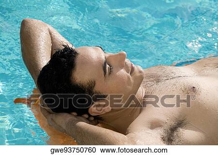 Close-up of a young man lying on a raft in a swimming pool View Large Photo Image Stock Image - Close-up of a young man lying on a raft in a swimming pool. Fotosearch