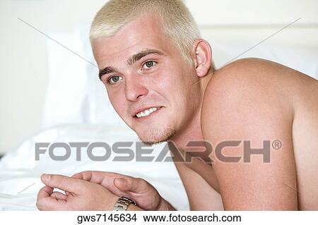 Close-up of a young man lying on the bed View Large Photo Image Picture - Close-up of a young man lying on the bed. Fotosearch