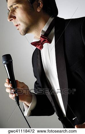 Close-up of a young man singing into a microphone View Large Photo Image Stock Image - Close-up of a young man singing into a microphone. Fotosearch