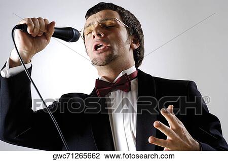 Close-up of a young man singing into a microphone View Large Photo Image Stock Image - Close-up of a young man singing into a microphone. Fotosearch