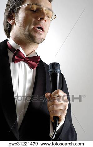 Close-up of a young man singing into a microphone View Large Photo Image Stock Photo - Close-up of a young man singing into a microphone. Fotosearch