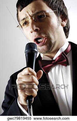 Close-up of a young man singing into a microphone View Large Photo Image Stock Photography - Close-up of a young man singing into a microphone. Fotosearch
