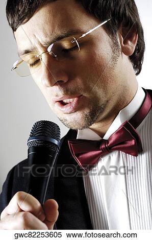 Stock Photography - Close-up of a young man singing into a microphone. Fotosearch