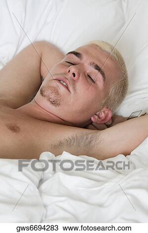 Close-up of a young man sleeping on the bed View Large Photo Image Stock Image - Close-up of a young man sleeping on the bed. Fotosearch