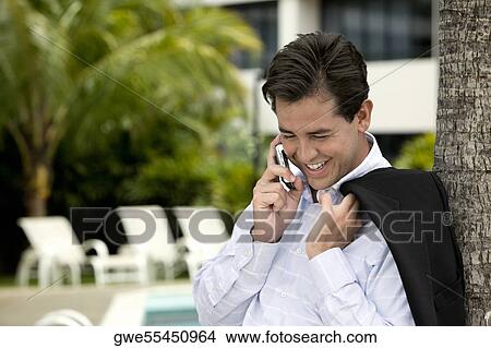 Close-up of a young man talking on a mobile phone View Large Photo Image Picture - Close-up of a young man talking on a mobile phone. Fotosearch