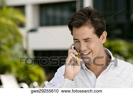 Close-up of a young man talking on a mobile phone View Large Photo Image Stock Image - Close-up of a young man talking on a mobile phone. Fotosearch