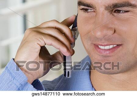 Close-up of a young man talking on a mobile phone View Large Photo Image Stock Image - Close-up of a young man talking on a mobile phone. Fotosearch