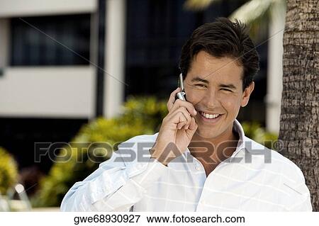 Close-up of a young man talking on a mobile phone View Large Photo Image Stock Photo - Close-up of a young man talking on a mobile phone. Fotosearch