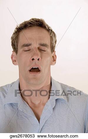 Stock Image - Close-up of a young man yawning. Fotosearch