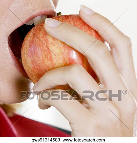 Close-up of a young woman biting an apple View Large Photo Image Stock Photo - Close-up of a young woman biting an apple. Fotosearch