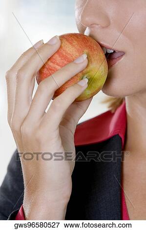 Close-up of a young woman biting an apple View Large Photo Image Stock Photo - Close-up of a young woman biting an apple. Fotosearch