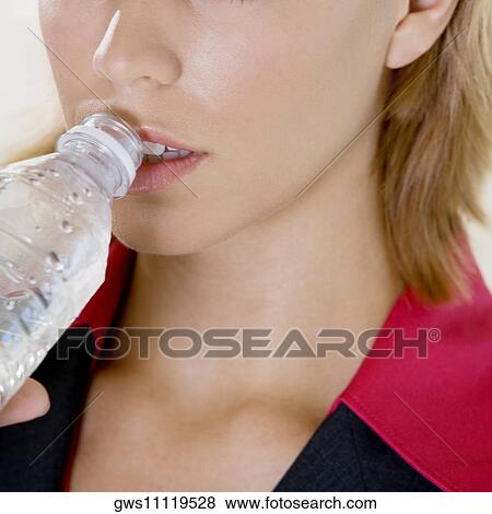 Close-up of a young woman drinking water from a bottle View Large Photo Image Stock Photo - Close-up of a young woman drinking water from a bottle. Fotosearch