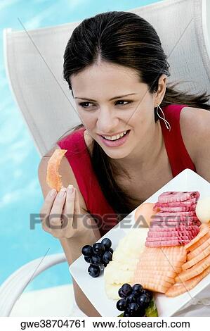 Close-up of a young woman eating fruit salad View Large Photo Image Stock Image - Close-up of a young woman eating fruit salad. Fotosearch