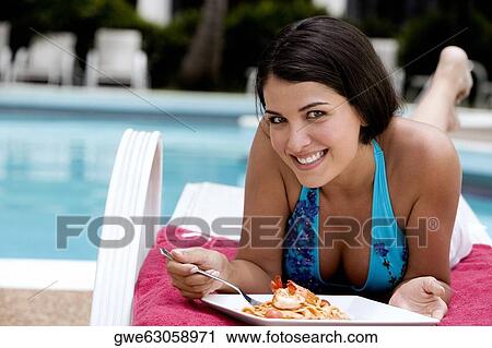 Stock Image - Close-up of a young woman having a meal. Fotosearch