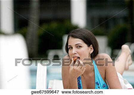 Close-up of a young woman having a meal View Large Photo Image Stock Photo - Close-up of a young woman having a meal. Fotosearch