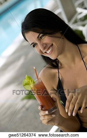 Picture - Close-up of a young woman holding a drink. Fotosearch
