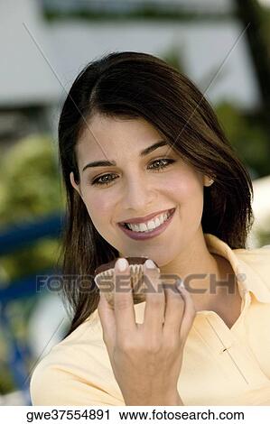 Close-up of a young woman holding a muffin View Large Photo Image Stock Image - Close-up of a young woman holding a muffin. Fotosearch