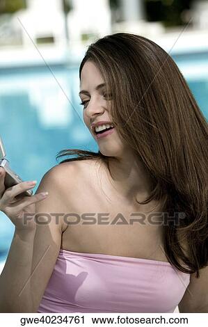 Close-up of a young woman holding a mobile phone View Large Photo Image Stock Image - Close-up of a young woman holding a mobile phone. Fotosearch