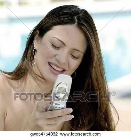 Close-up of a young woman holding a mobile phone View Large Photo Image Stock Image - Close-up of a young woman holding a mobile phone. Fotosearch