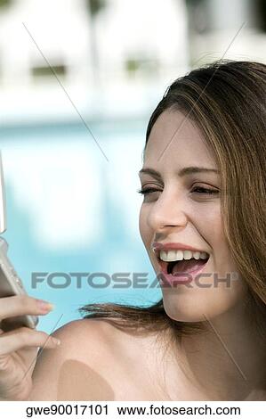 Close-up of a young woman holding a mobile phone View Large Photo Image Stock Image - Close-up of a young woman holding a mobile phone. Fotosearch