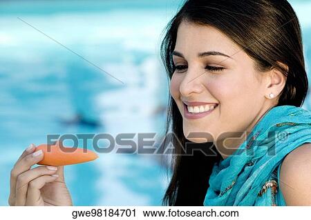 Close-up of a young woman holding a carrot View Large Photo Image Stock Image - Close-up of a young woman holding a carrot. Fotosearch