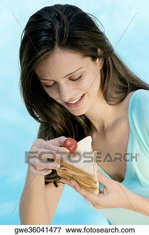 Close-up of a young woman holding a sandwich View Large Photo Image Stock Photo - Close-up of a young woman holding a sandwich. Fotosearch