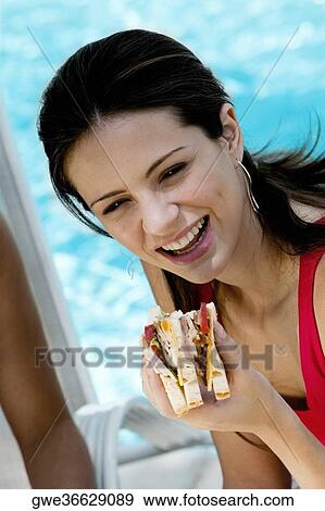 Close-up of a young woman holding a sandwich View Large Photo Image Stock Photo - Close-up of a young woman holding a sandwich. Fotosearch