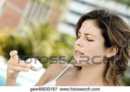 Stock Photo - Close-up of a young woman holding a cupcake. Fotosearch