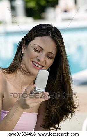 Close-up of a young woman holding a mobile phone View Large Photo Image Stock Photo - Close-up of a young woman holding a mobile phone. Fotosearch