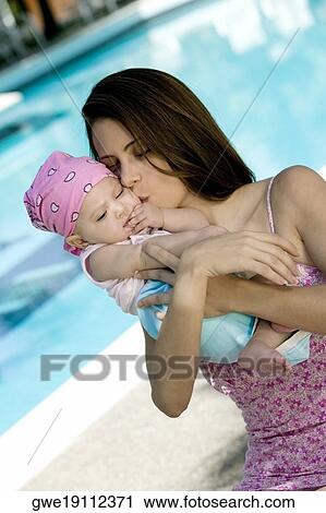 Stock Image - Close-up of a young woman holding her daughter. Fotosearch