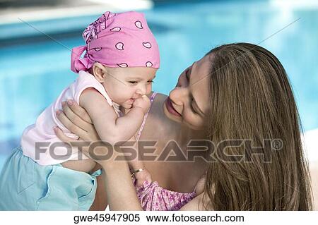 Close-up of a young woman holding her daughter View Large Photo Image Stock Photography - Close-up of a young woman holding her daughter. Fotosearch
