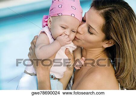 Close-up of a young woman kissing her daughter View Large Photo Image Picture - Close-up of a young woman kissing her daughter. Fotosearch