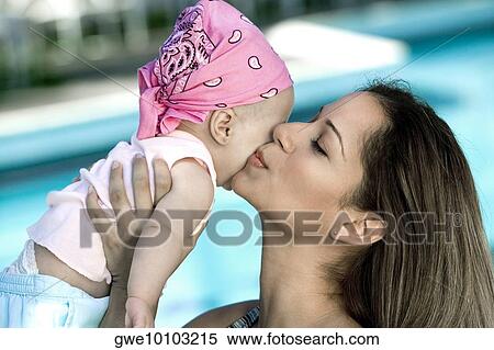 Stock Photography - Close-up of a young woman kissing her daughter. Fotosearch