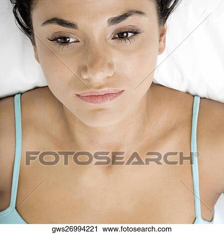 Close-up of a young woman lying on a bed View Large Photo Image Stock Image - Close-up of a young woman lying on a bed. Fotosearch