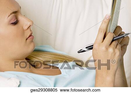 Close-up of a young woman reading a book View Large Photo Image Stock Photography - Close-up of a young woman reading a book. Fotosearch