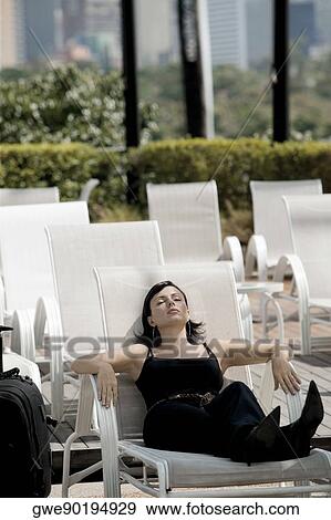 Stock Photo - Close-up of a young woman relaxing on a lounge chair. Fotosearch
