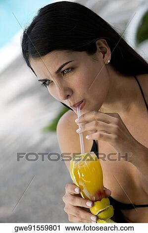 Close-up of a young woman sipping drink from a glass View Large Photo Image Stock Image - Close-up of a young woman sipping drink from a glass. Fotosearch