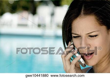 Close-up of a young woman talking on a mobile phone View Large Photo Image Stock Image - Close-up of a young woman talking on a mobile phone. Fotosearch