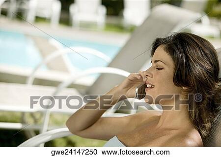 Close-up of a young woman talking on a mobile phone View Large Photo Image Stock Image - Close-up of a young woman talking on a mobile phone. Fotosearch