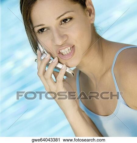 Close-up of a young woman talking on a mobile phone View Large Photo Image Stock Image - Close-up of a young woman talking on a mobile phone. Fotosearch