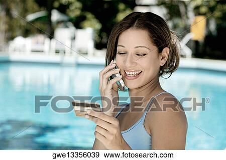 Close-up of a young woman talking on a mobile phone View Large Photo Image Stock Photo - Close-up of a young woman talking on a mobile phone. Fotosearch